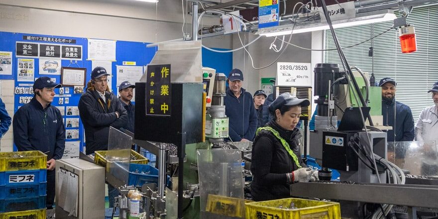 Un grupo de profesionales internacionales de la lean manufacturing visita una fábrica durante un viaje de estudio sobre kaizen en Japón
